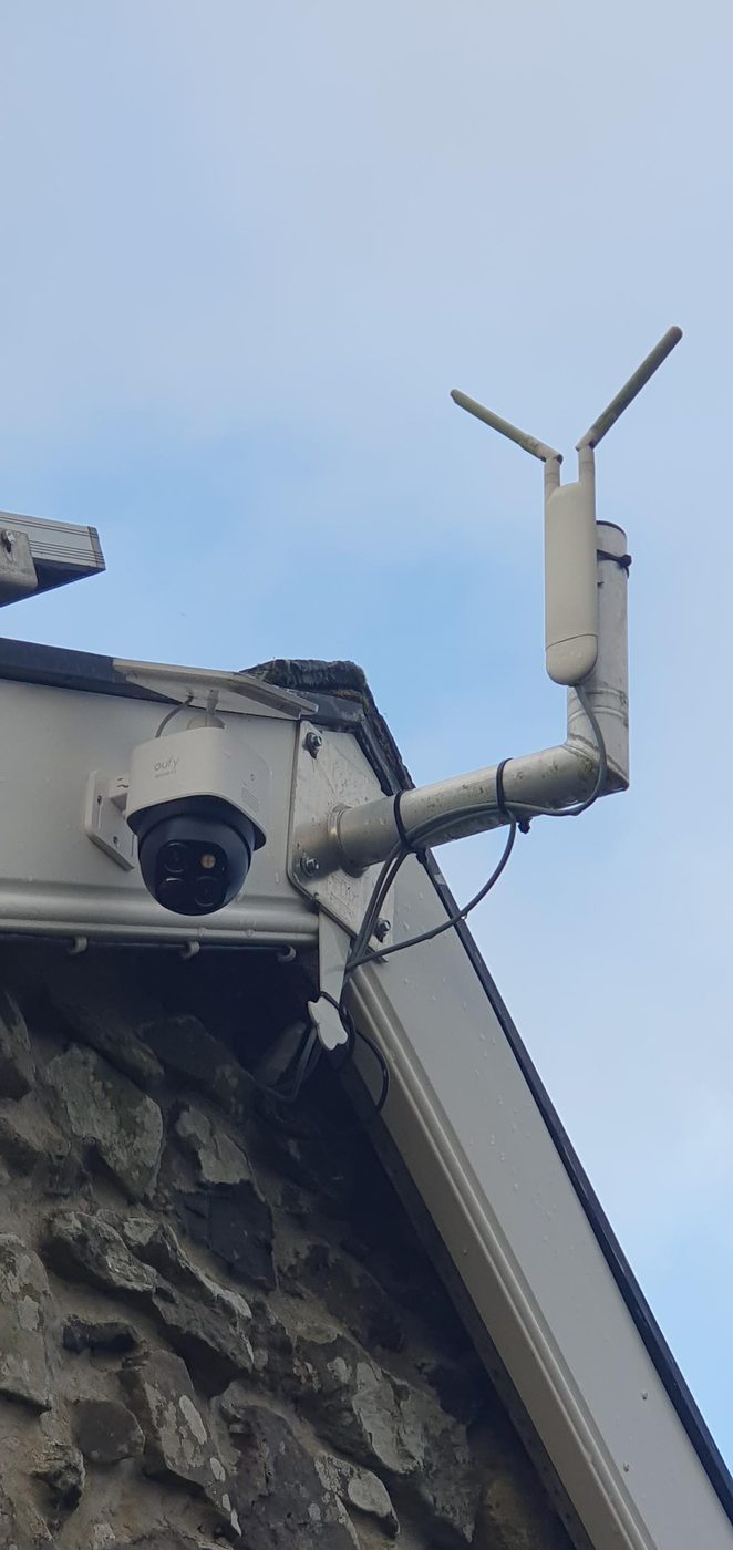 Security camera and Wi-Fi antenna on a stone barn gable