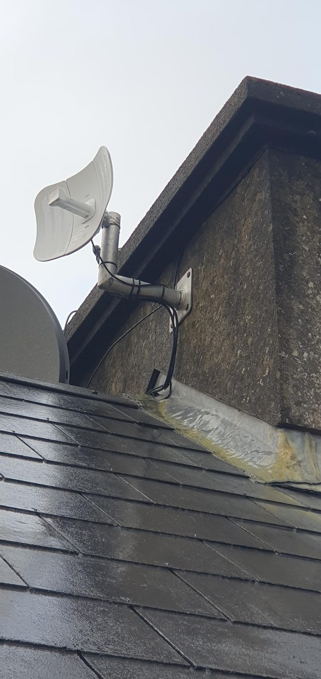 Wireless link antenna on a bracket above a slate roof
