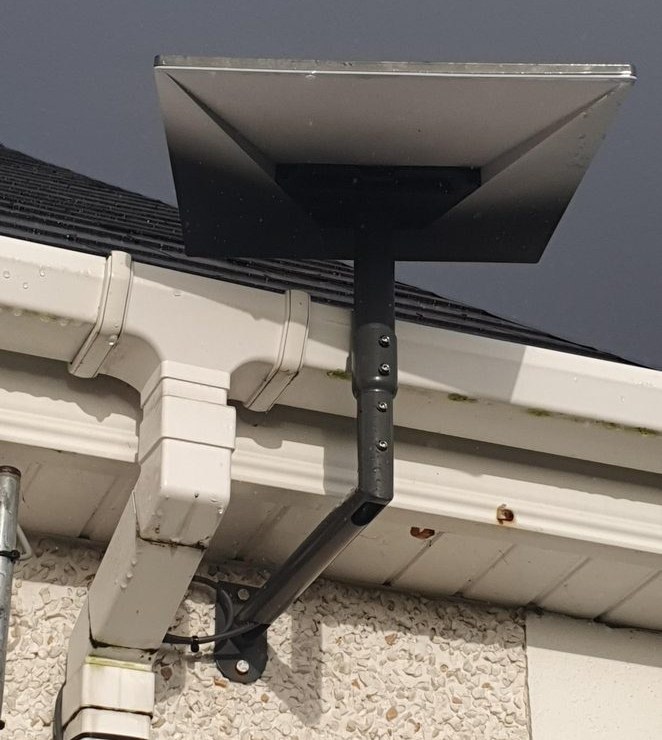 Starlink dish on a wall bracket under the eaves
