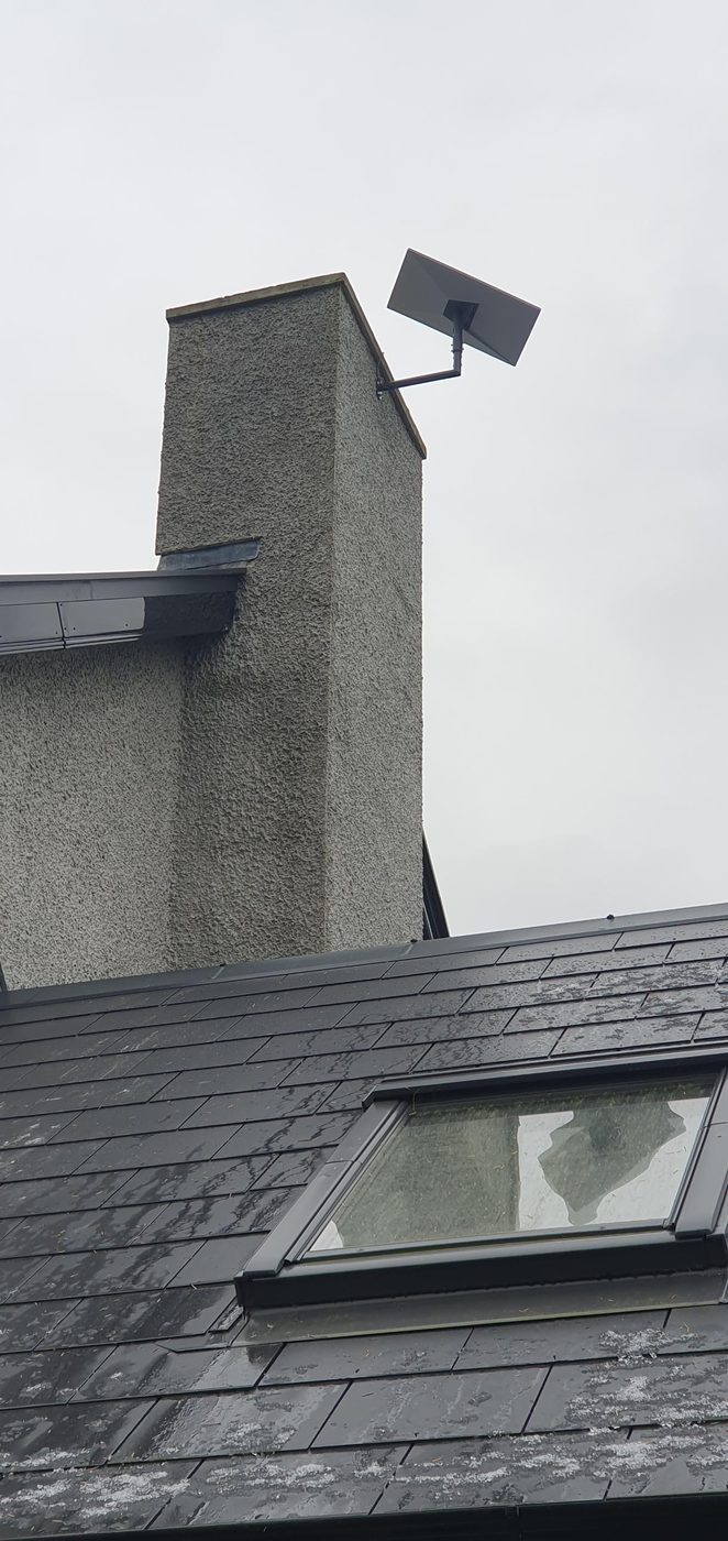 Starlink dish on a chimney stack above a slate roof
